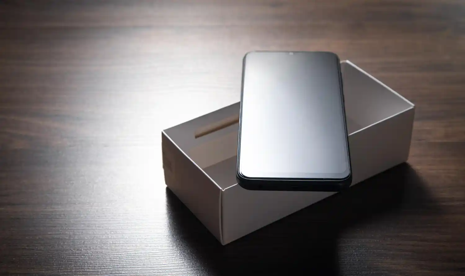 Używany smartfon położony na pudełku przed przygotowaniem do sprzedaży i wyceny